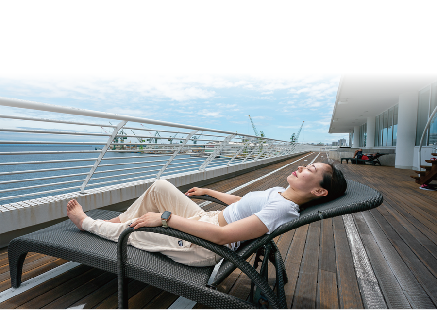 テラスで外気浴を楽しむ女性の写真